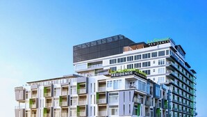 A multi-story hotel with balconies, a rooftop terrace, and a parking area. - La Grande Residence- Grand Studio - Angeles/ Clark (Angeles)