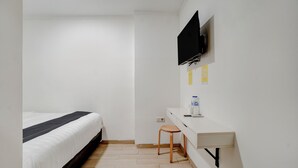 A small, clean room with a bed, a desk, and a TV mounted on the wall. - Hotel O near Monas formerly Cideng Timur Residence (Jakarta)