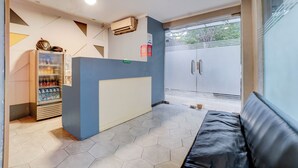A reception area with a blue counter, a water dispenser, and a seating area. - Hotel O near Monas formerly Cideng Timur Residence (Jakarta)