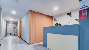 A reception area with a blue counter, a reception desk, and a sign indicating the reception. - Hotel O near Monas formerly Cideng Timur Residence (Jakarta)