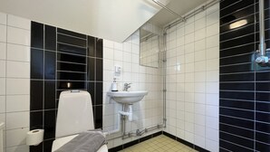 A modern bathroom with a toilet, sink, and shower. - AlingsÃ¥s Vandrarhem - Villa Plantaget - Hostel (Alingsas)