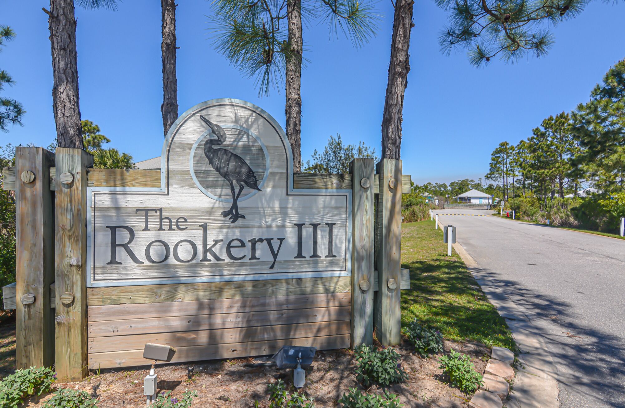 A wooden sign with a bird and the text "The Rookery III".