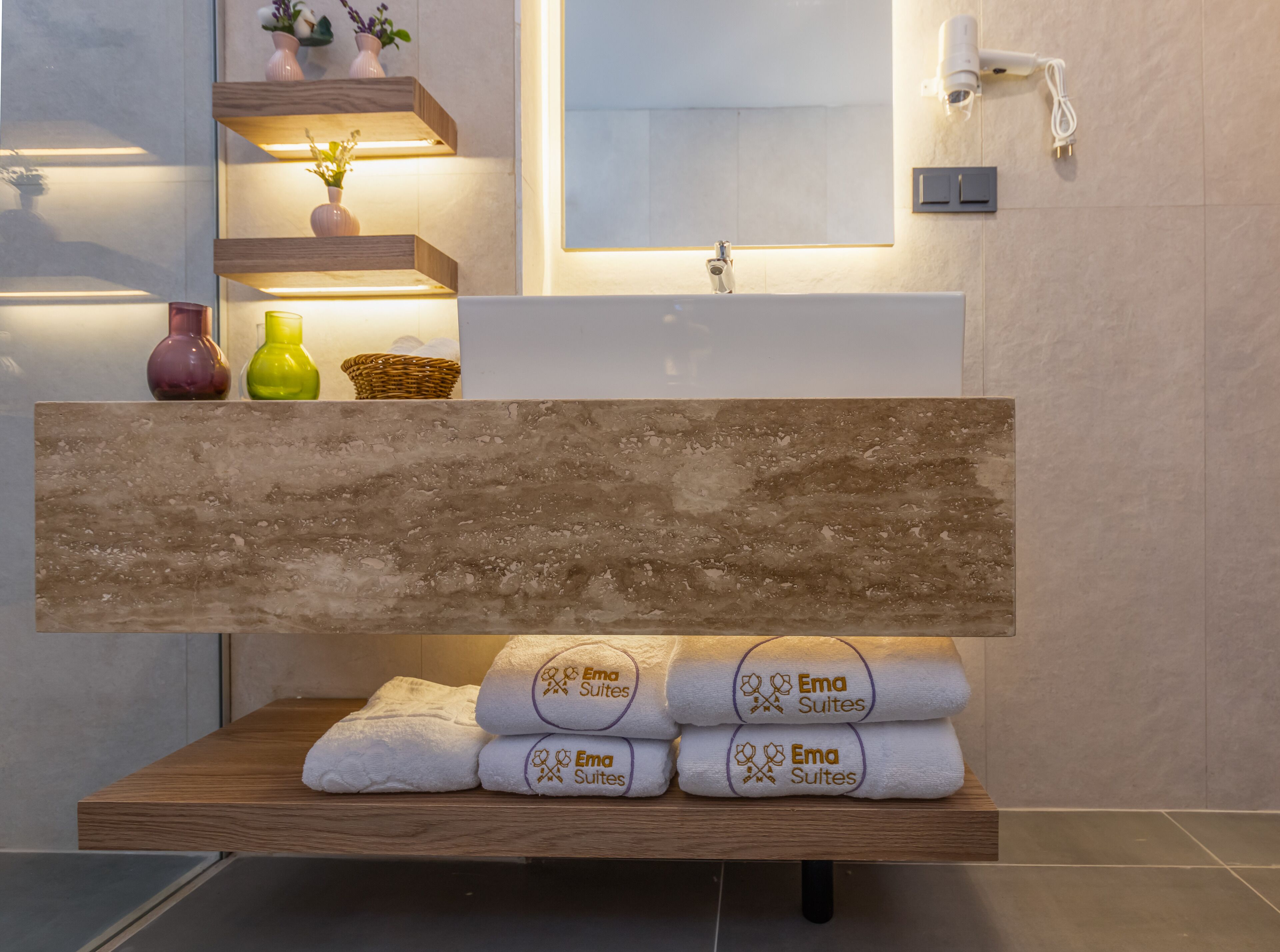 Un baño con tocador de madera, un espejo y una repisa con adornos.
