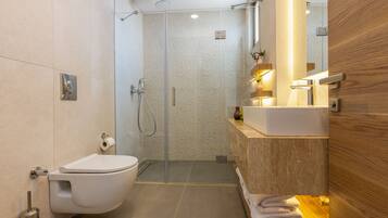 A modern bathroom with a toilet, shower, and sink.