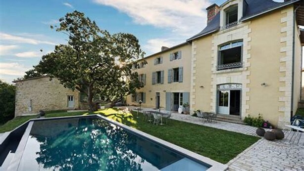 A large house with a swimming pool, a garden, and a balcony.