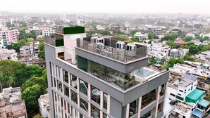 Un edificio moderno con terraza en la azotea, ventanas amplias y un letrero que dice "HORIZON".