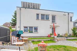 A two-story building with a flat roof, a visible chimney, and a nameplate on the side. - Traumhafte Strandnah-wohnung in Koserow für Zwei (Koserow)