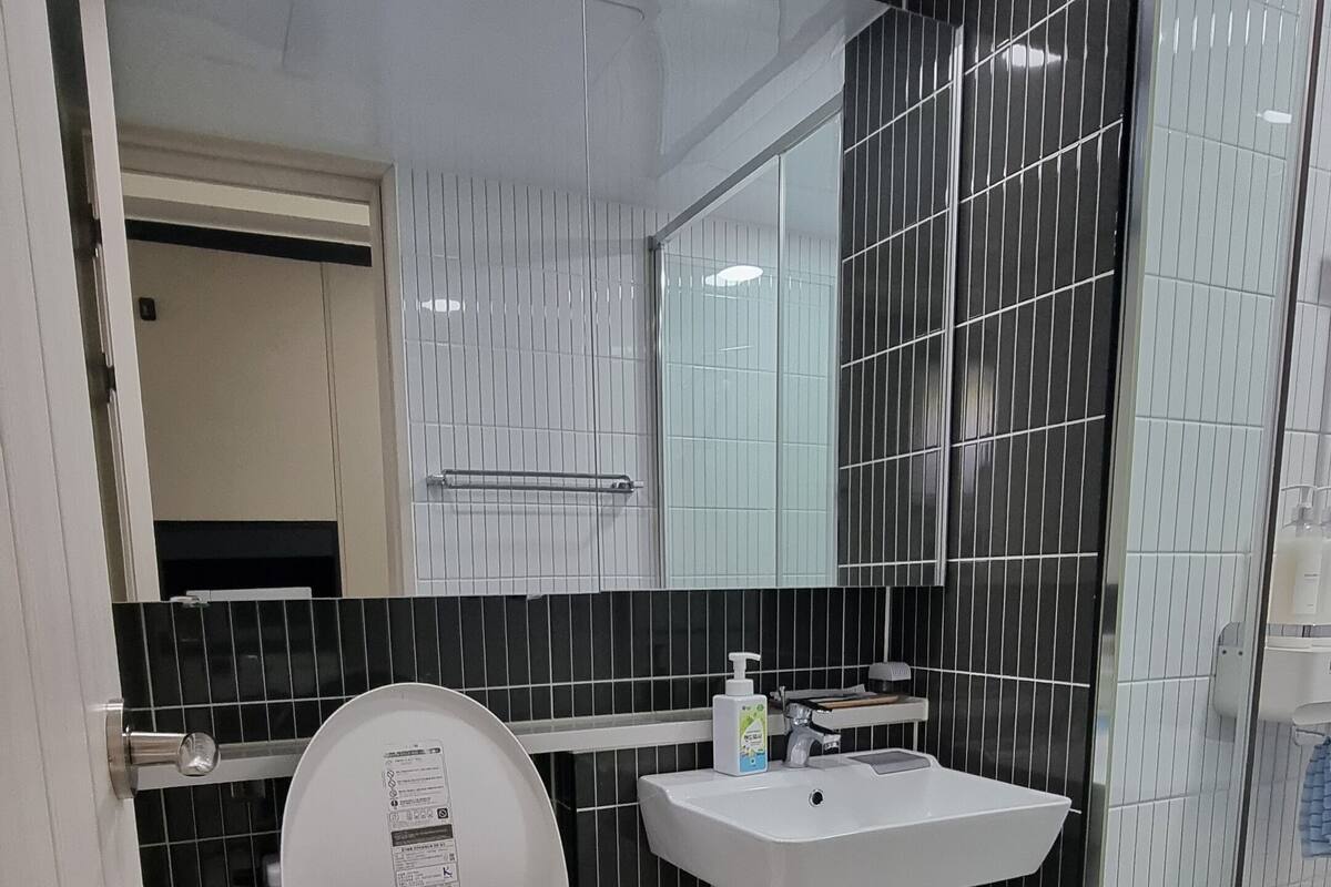 A modern bathroom with a toilet, a sink, and a mirror.