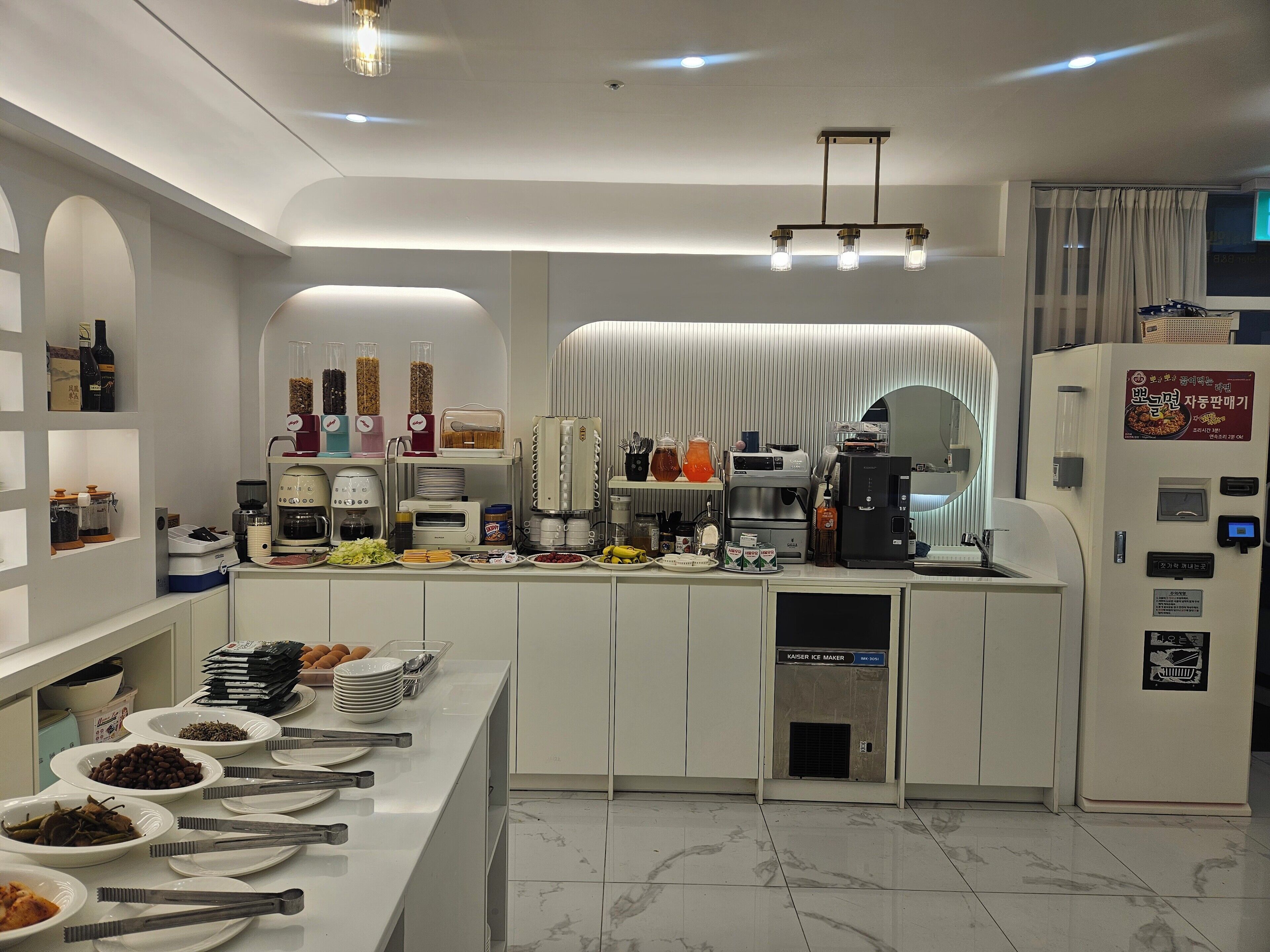Una cocina moderna con una presentación tipo bufé, que incluye diversos alimentos y electrodomésticos.