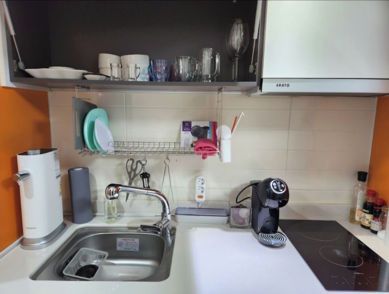 A kitchen with a sink, a coffee maker, and a dish rack.