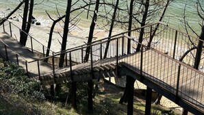 A wooden bridge with metal railings leading to a sandy beach with trees. - Appart Avec Terrasse vue Plage, 2 Minutes du Centre, 2 Vélos et Linge Fournis (Arcachon)