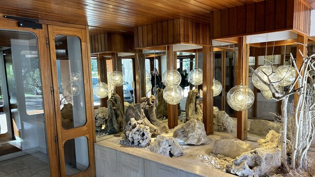 A modern interior with wooden paneling, a rock display, and hanging spherical light fixtures. - Appart Avec Terrasse vue Plage, 2 Minutes du Centre, 2 Vélos et Linge Fournis (Arcachon)