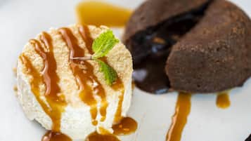 A dessert with caramel sauce and mint on a white plate.