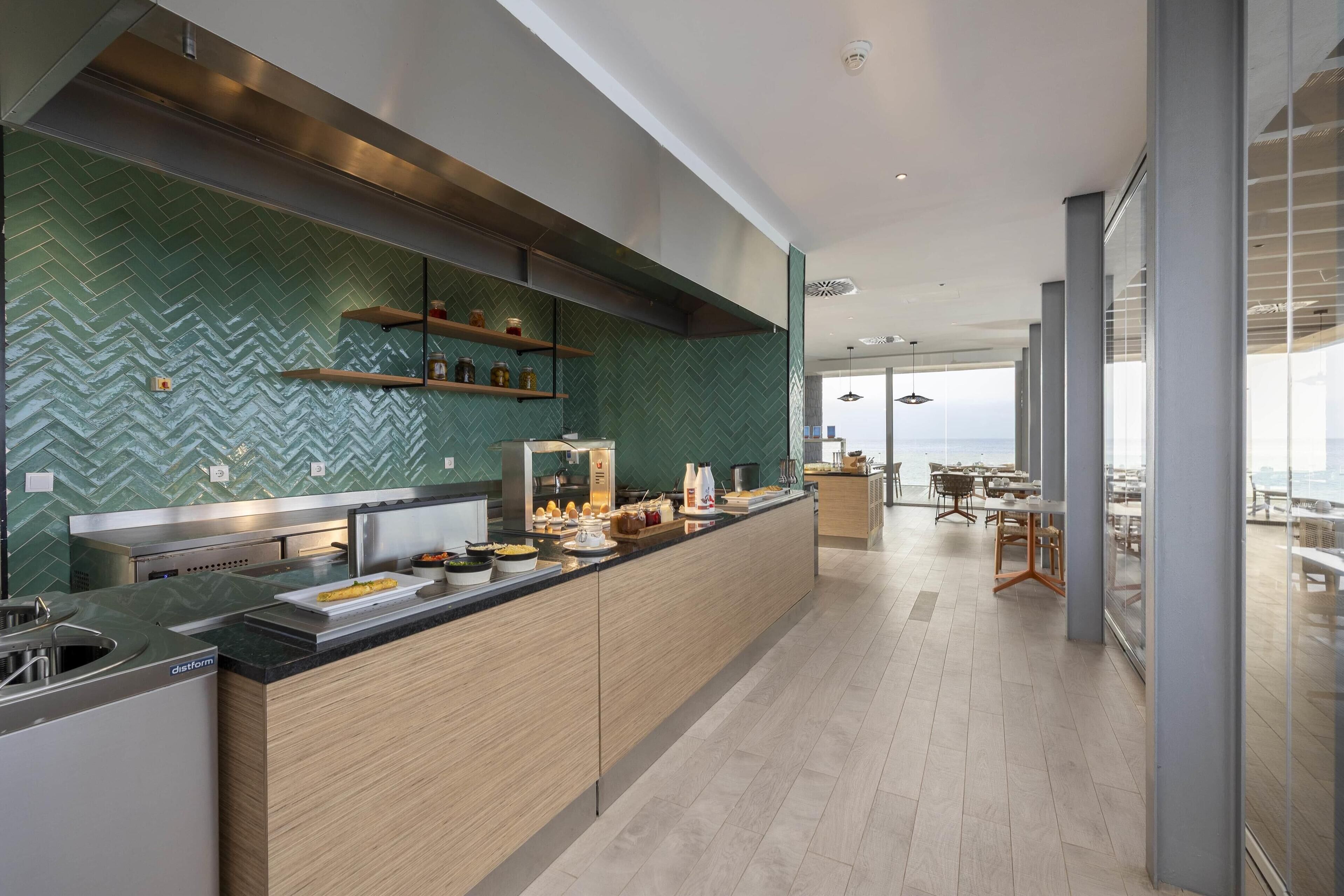 A modern kitchen with a herringbone tile backsplash, wooden cabinets, and a central island with various kitchen items.