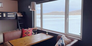 Una habitación con una litera, una mesa de madera y un banco.