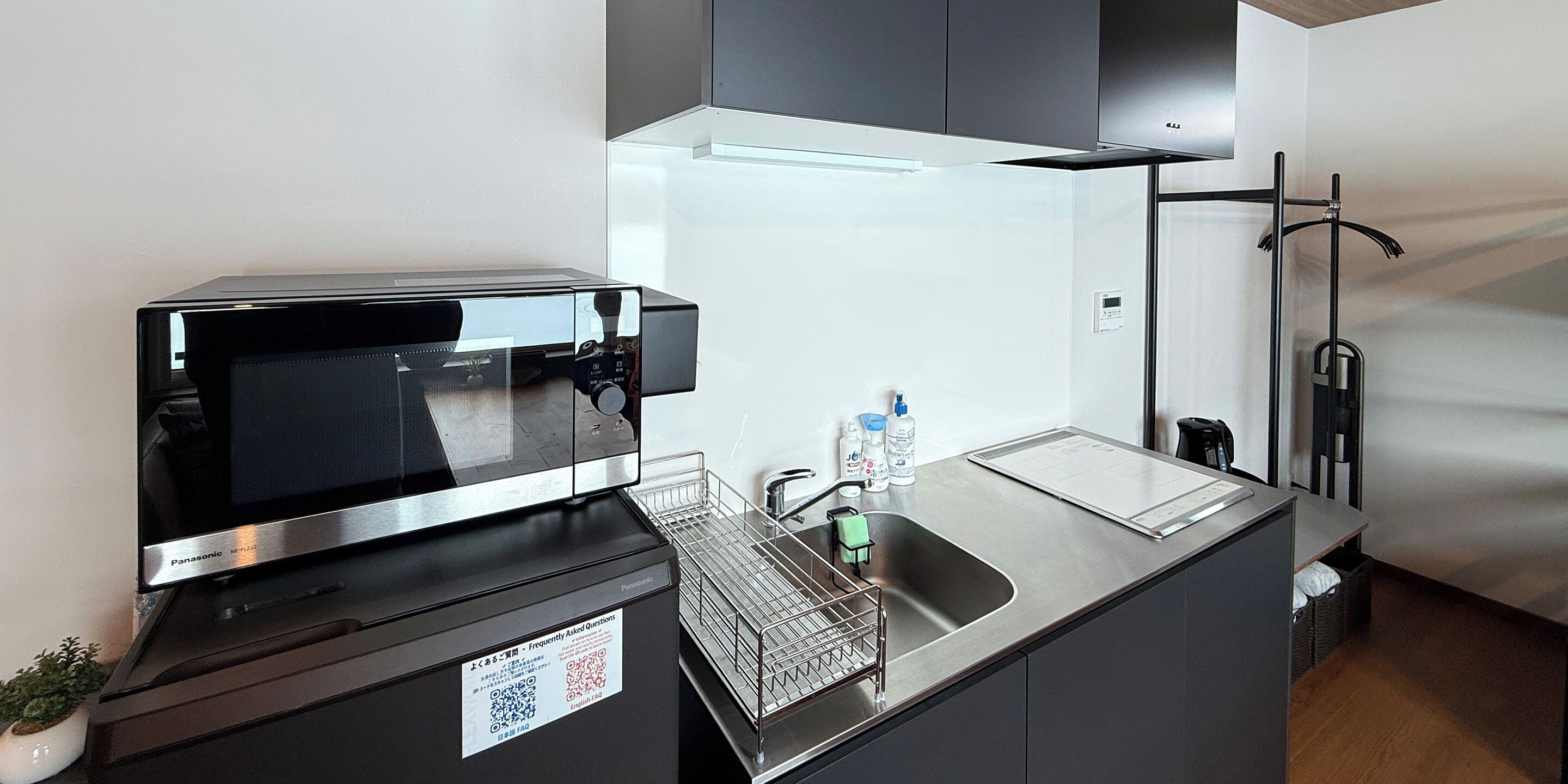 A compact kitchen with a microwave, sink, and a small countertop.