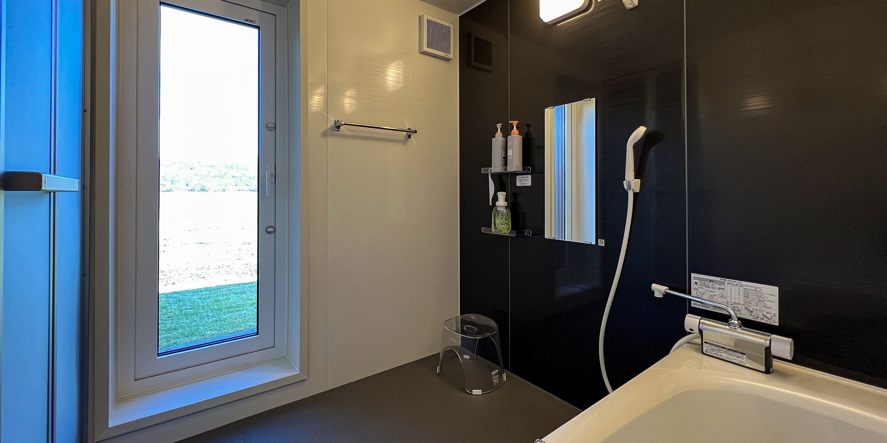 Un baño moderno con bañera, ducha y ventana.