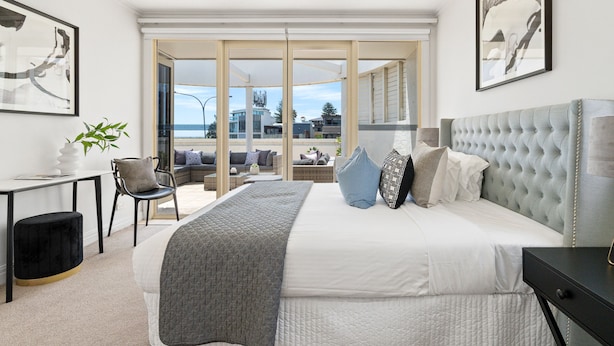 Un dormitorio moderno con una cama grande, un escritorio y vistas al exterior.