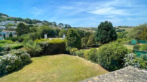 A well-maintained garden with a lawn, various shrubs, and trees. - Detached 4 bed Coastal Haven  | Garden  |  Parking (Salcombe)