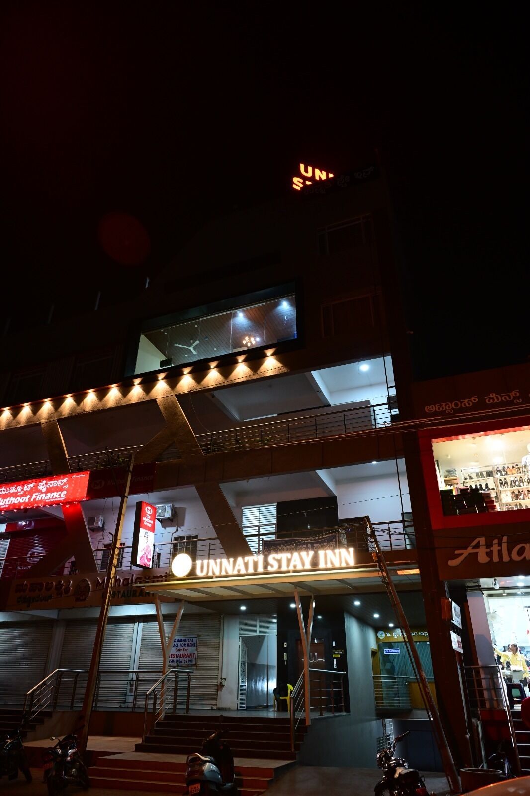 A multi-story building with a prominent "UNNATI STAY INN" sign.
