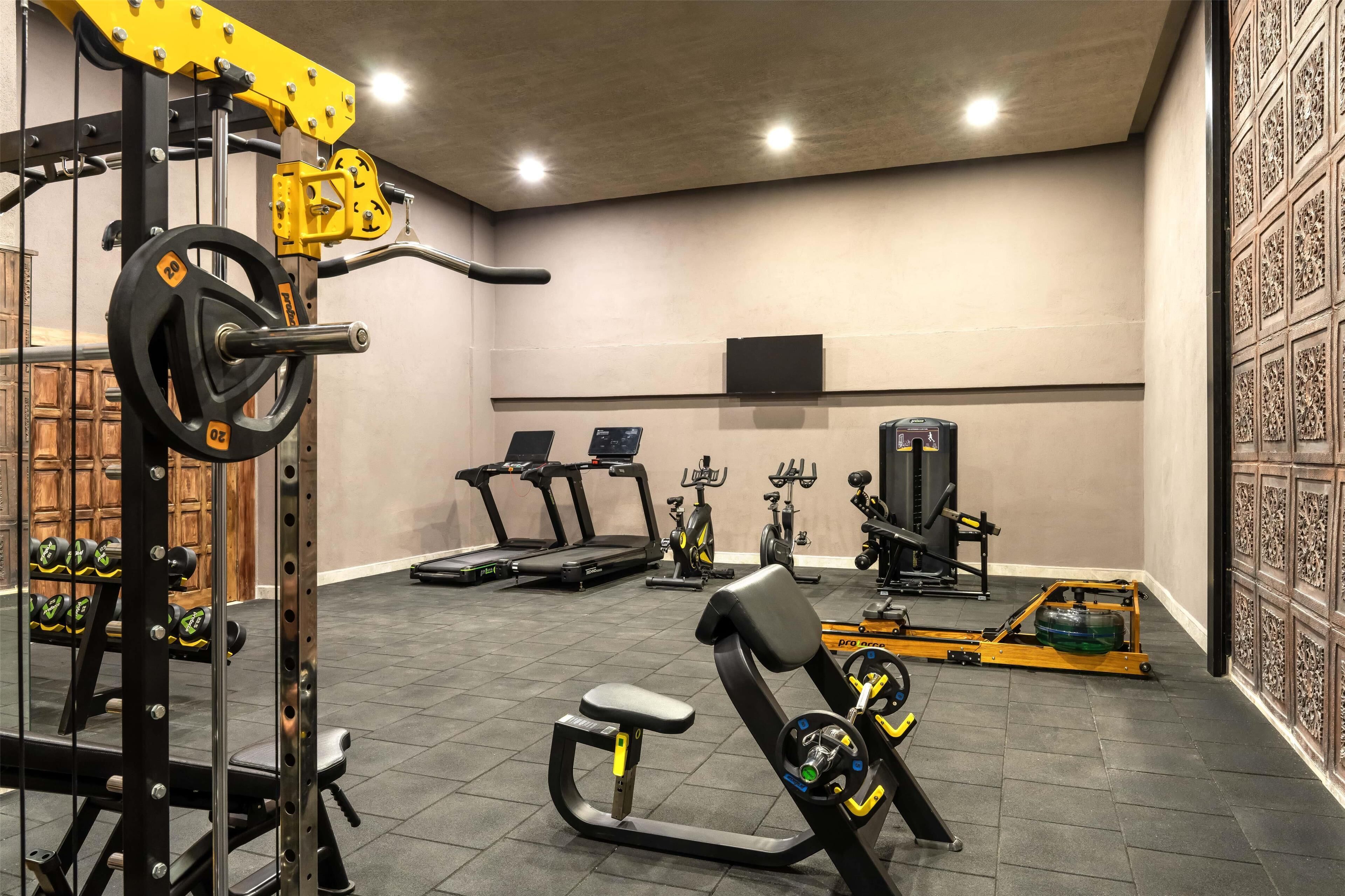 A gym with weightlifting equipment, treadmills, and stationary bikes.