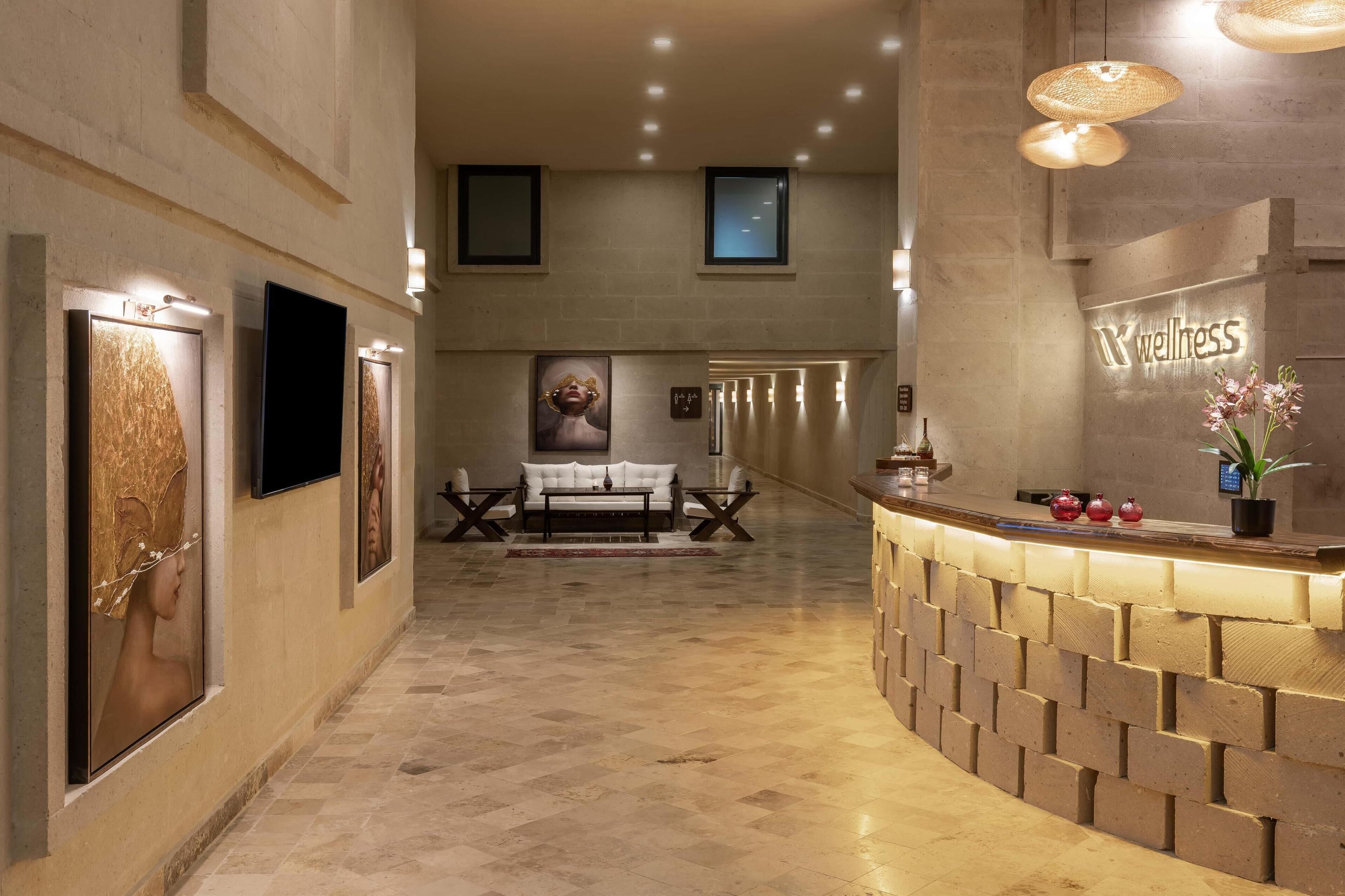 A reception area with a reception desk, a sofa, and a wall-mounted TV.