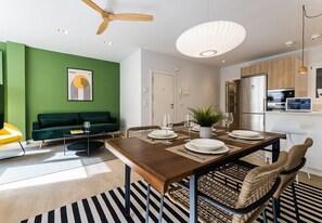 A modern dining area with a wooden table set for four, surrounded by wicker chairs. - Bright apartment with terrace near Zurriola Beach (San Sebastián)