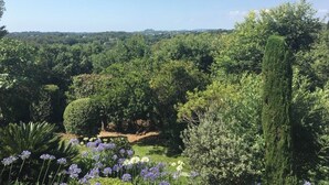 A lush garden with various trees and flowering plants. - Beautiful villa with stunning view nestled in countryside near Valbonne village  (OPIO)
