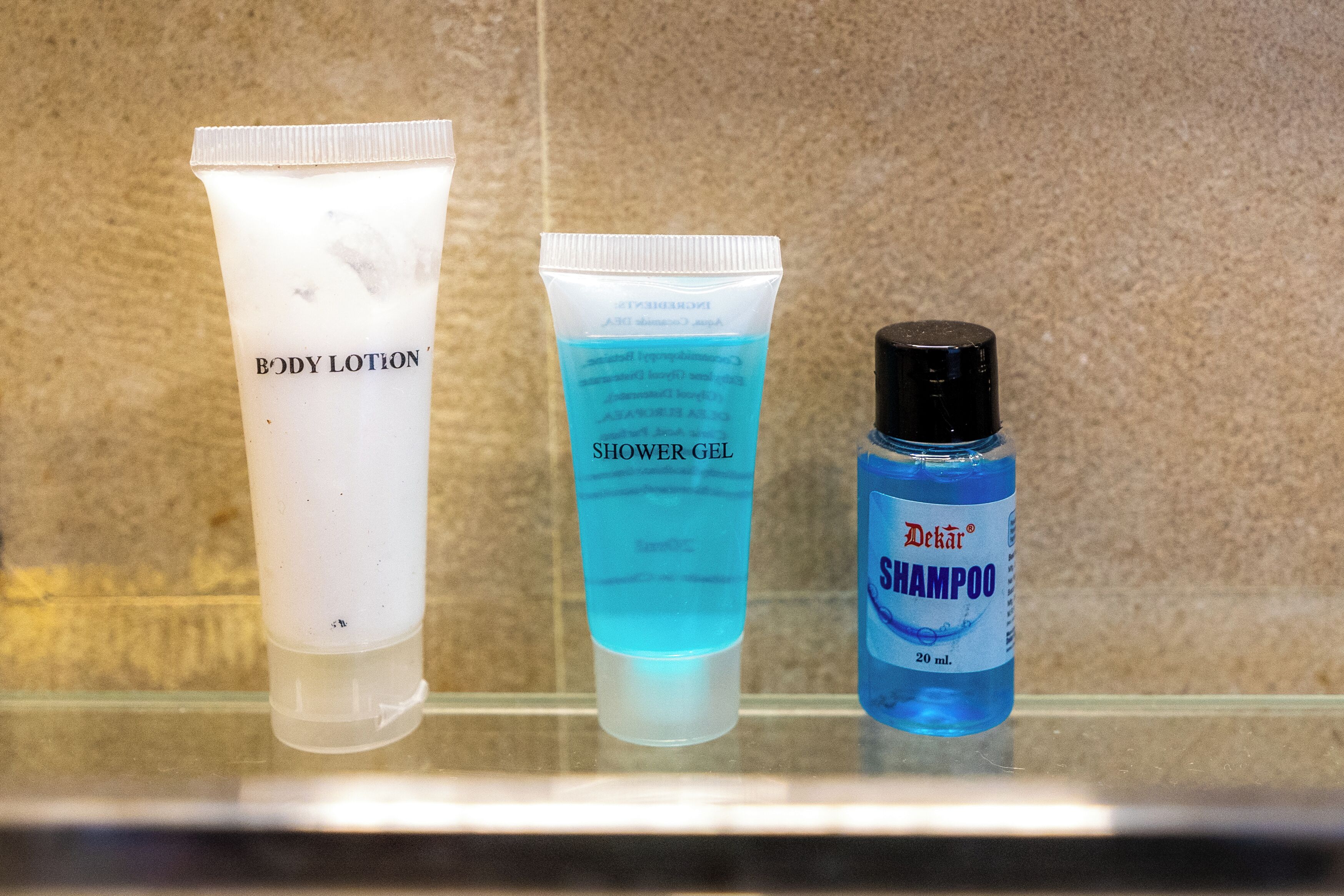Tres botellas de artículos de tocador sobre una encimera de baño.