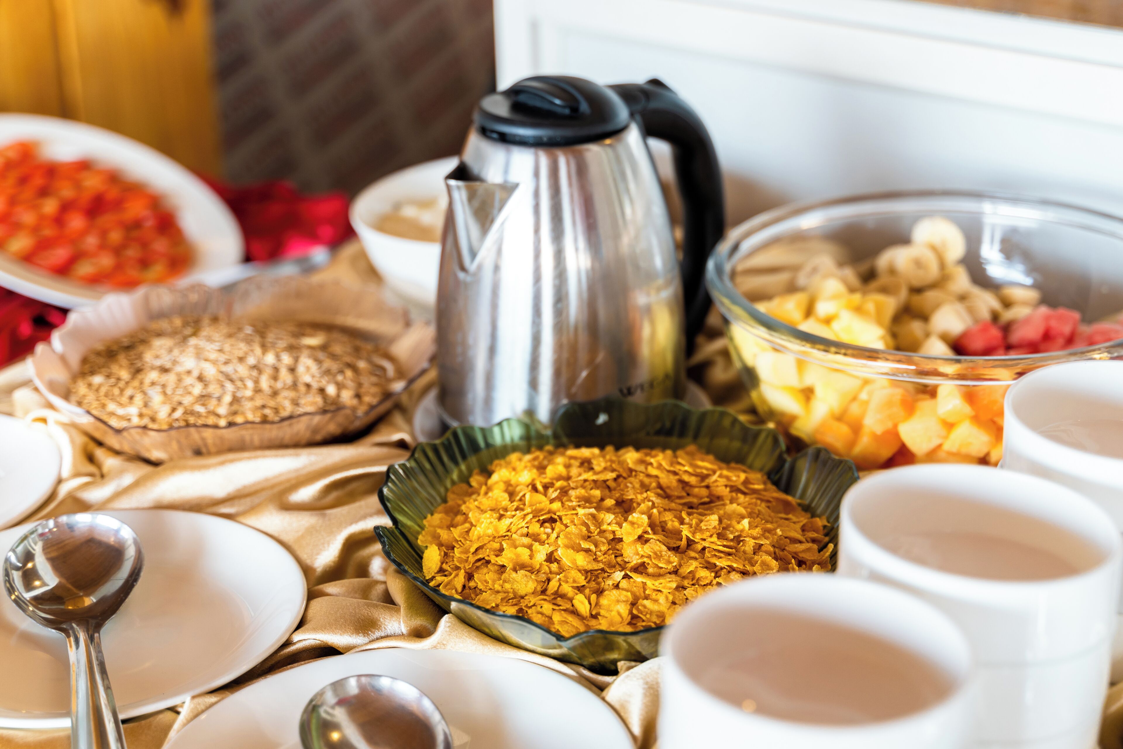 A buffet table with various food items and a coffee pot.