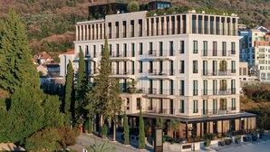 Et hotel i flere etager med moderne arkitektur, inklusiv altaner og en tagterrasse.