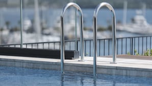 En swimmingpool med stålrækv og udsigt til både i baggrunden.