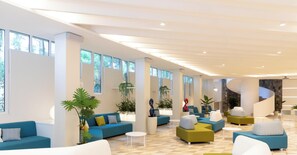 Eine moderne Hotelhalle mit blauen und grünen Sofas, weißen Couchtischen und großen Fenstern, die viel Tageslicht hereinlassen.