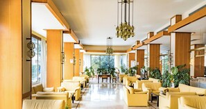 Eine großzügige Lobby mit hohen Decken, großen Fenstern und mehreren Sitzbereichen.