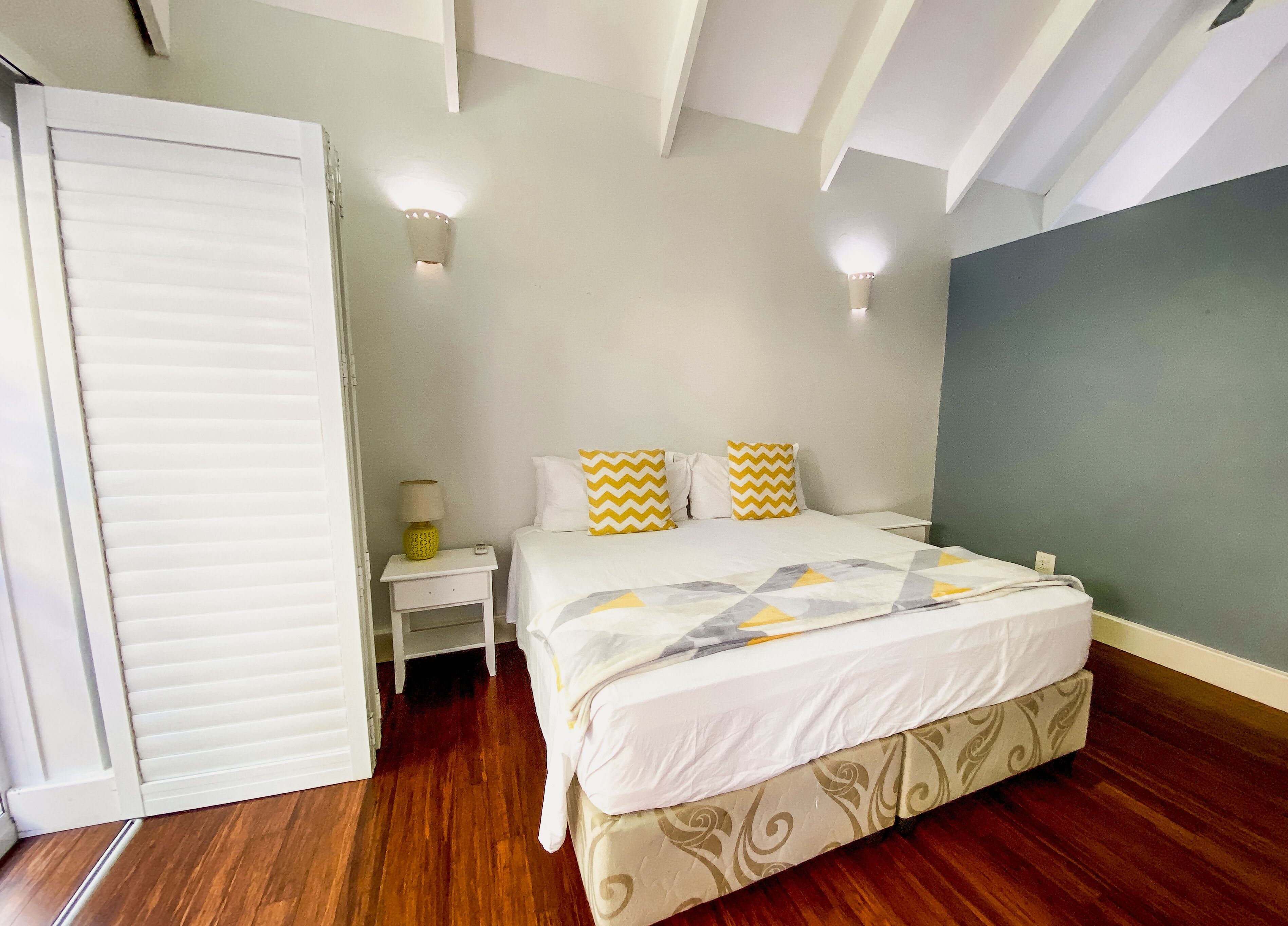 A bedroom with a bed, nightstand, and wardrobe.