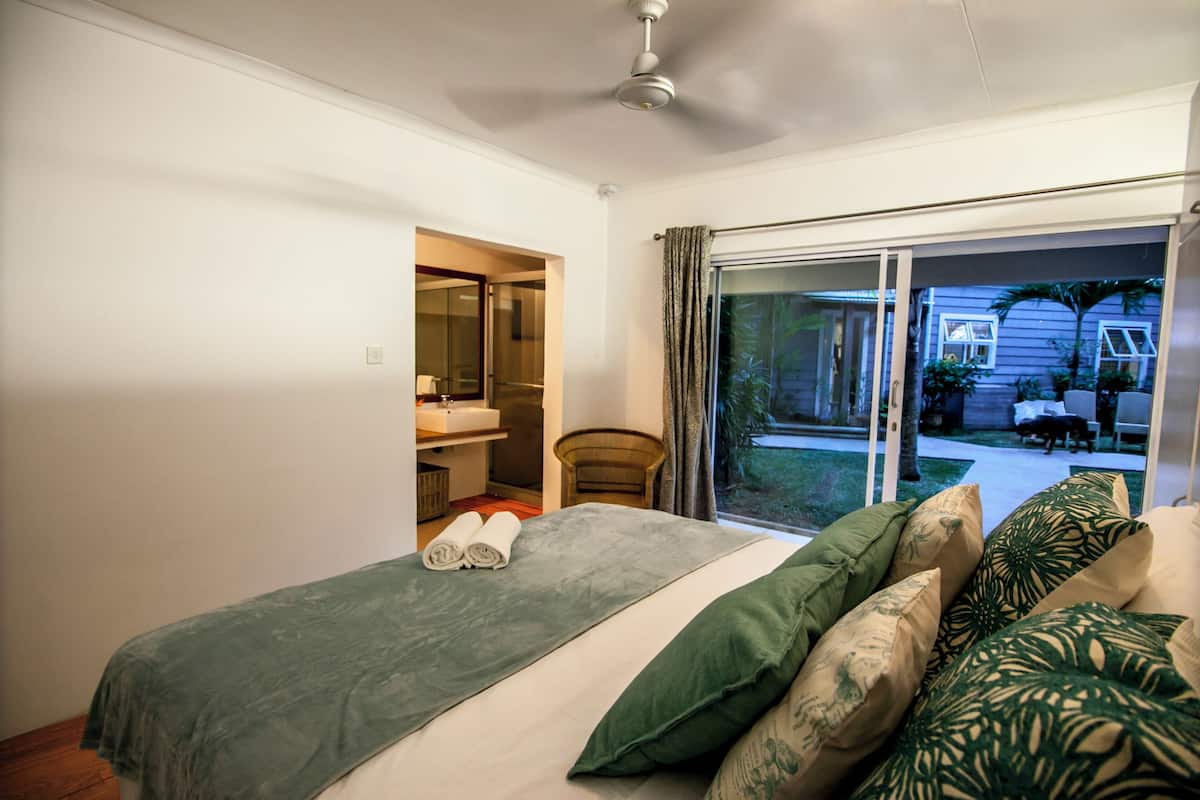 Ein Schlafzimmer mit Bett, Bad und Blick ins Freie.