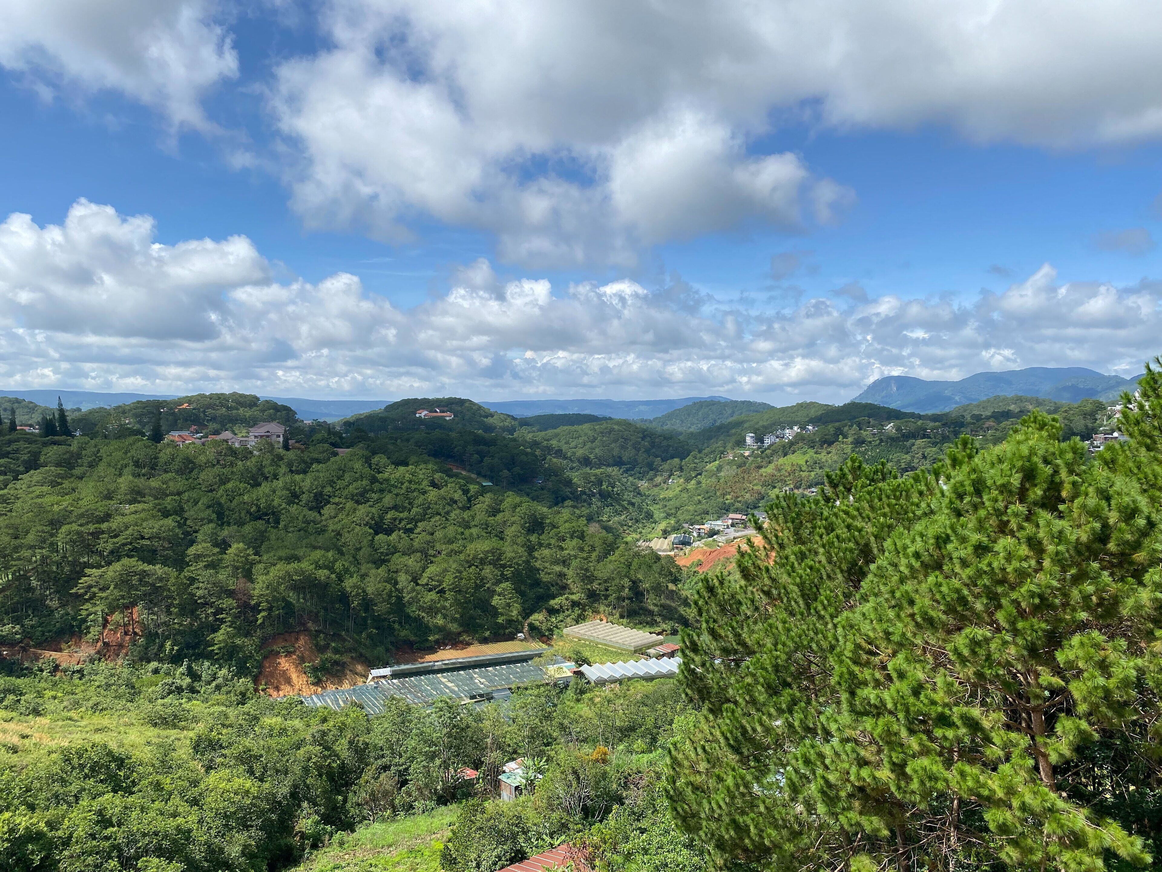 A mountainous landscape with a view of a valley and a building with a green roof.