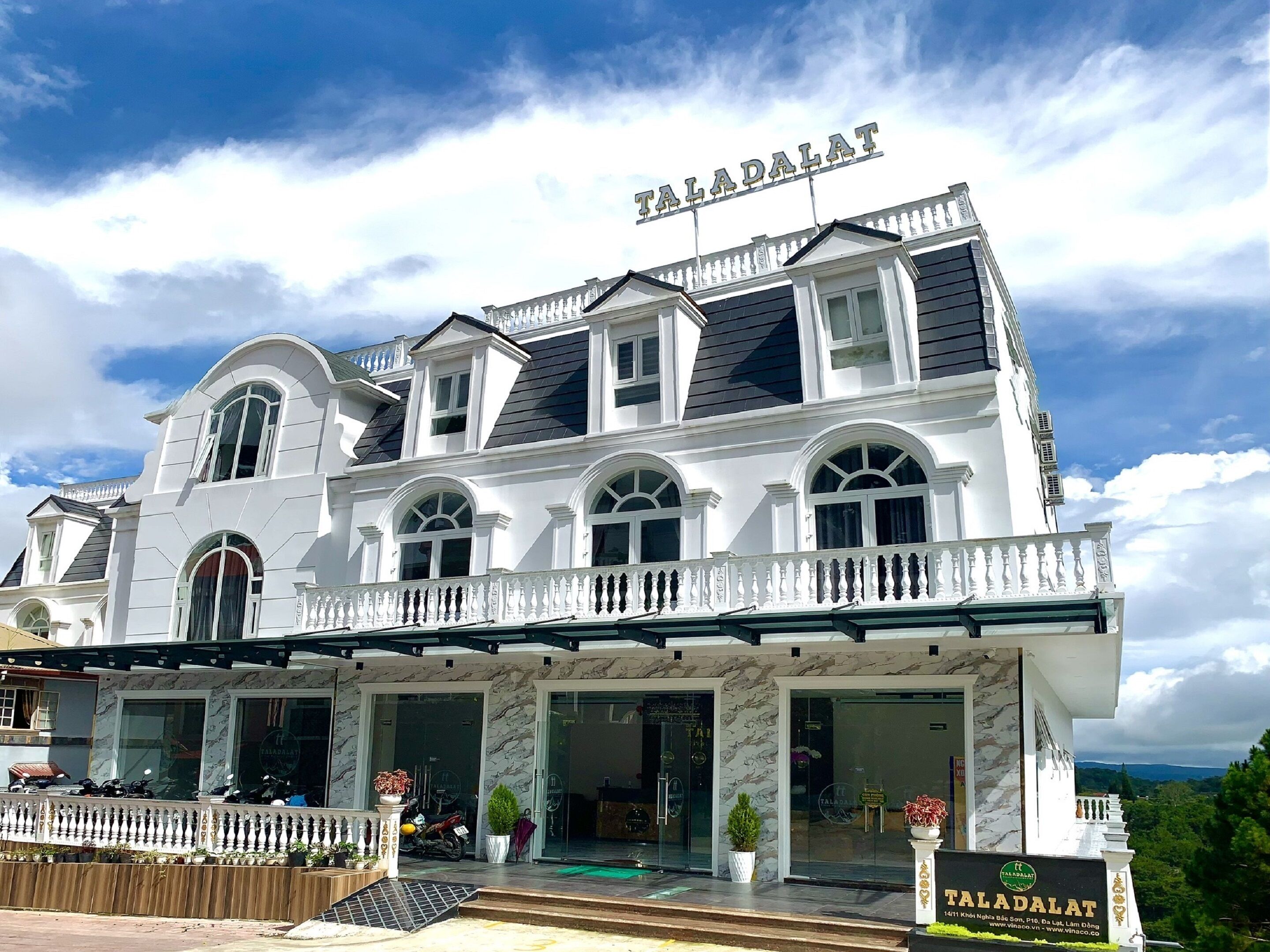 A large, white building with the name 'Taladalat' on the facade.