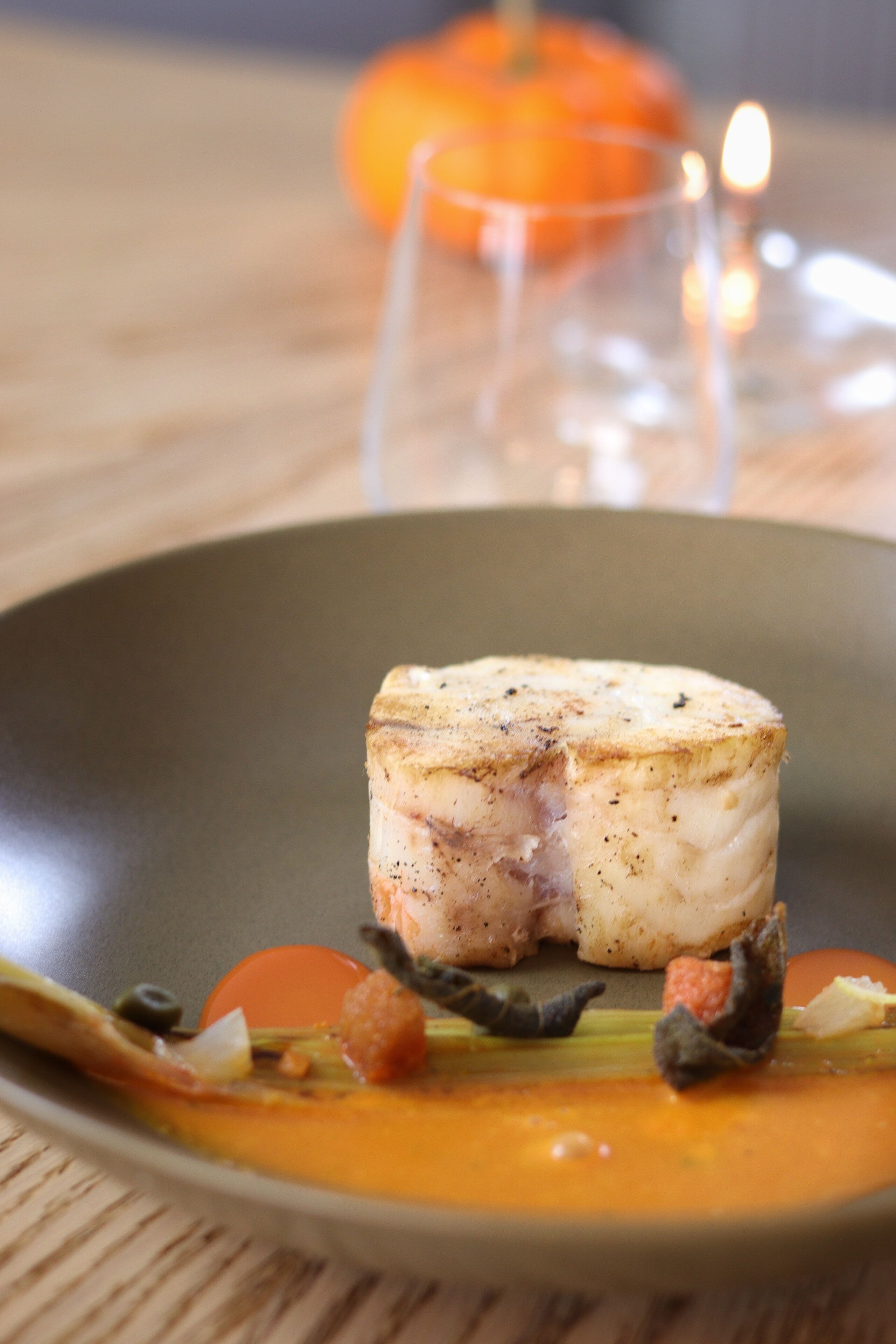 Un plat composé d’une tranche de viande servie dans une assiette, accompagnée de légumes et d’une sauce.