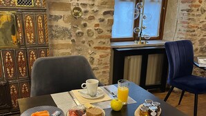 A breakfast setting with a table set for two, featuring croissants, waffles, eggs, and a glass of orange juice. - Hôtel Villa Pona (Digoin)