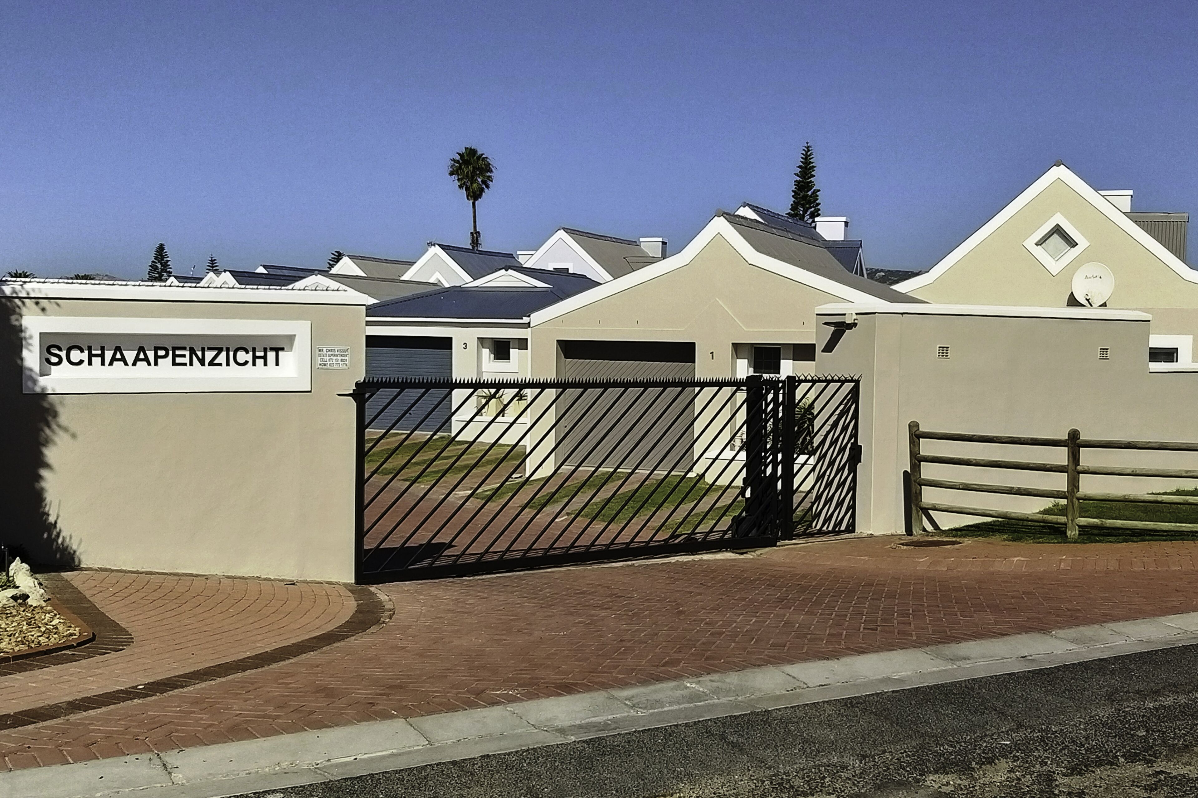 A gated residential complex with numbered units and a sign reading "SCHAAPENZICHT".