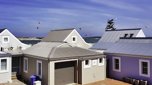 A residential area with houses, a garage, and a view of the sea. - Top Deck Langebaan 6-sleeper (Langebaan)