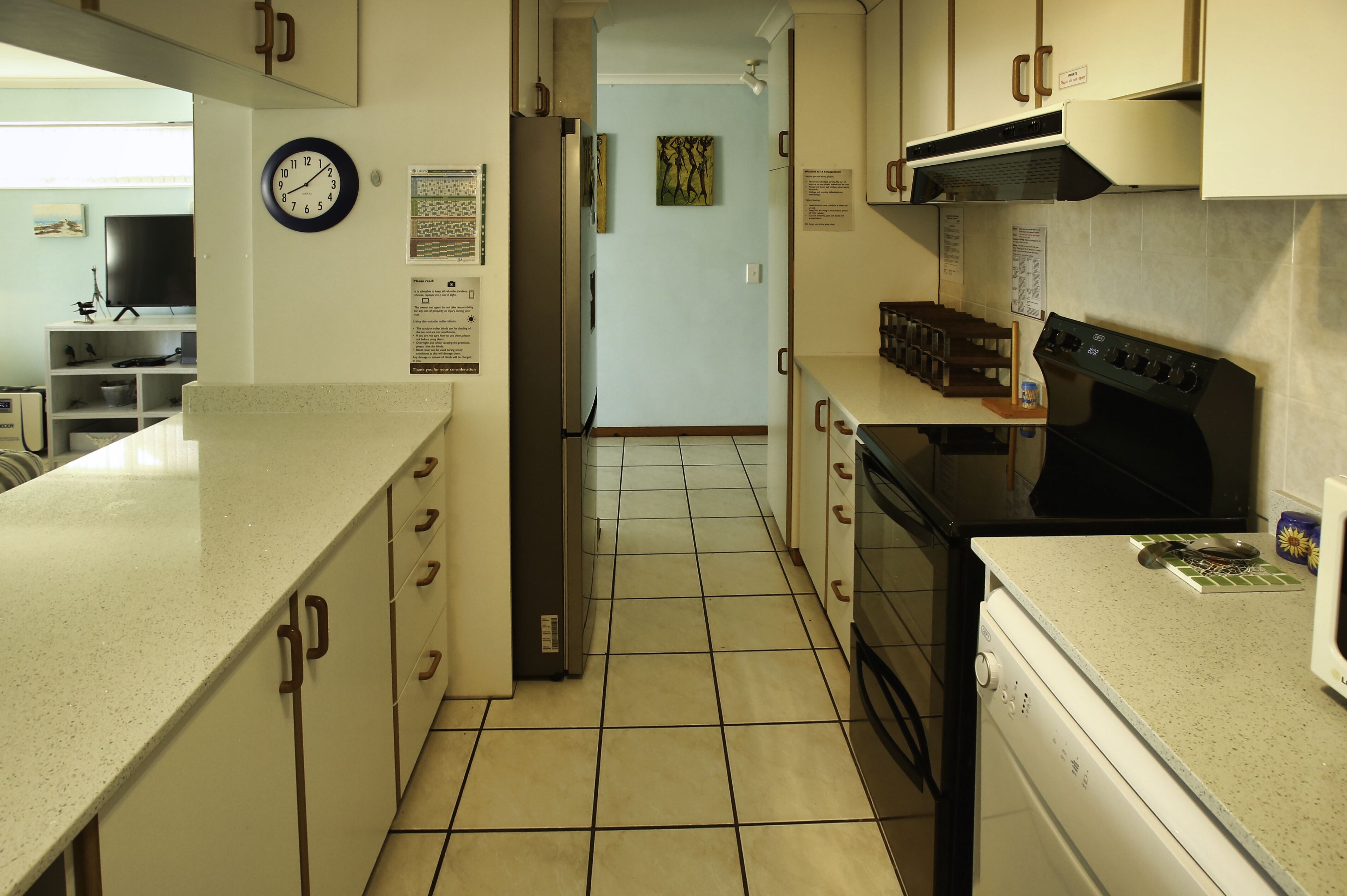 A kitchen with white cabinets, a black stove, and a microwave.