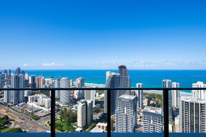 A cityscape with high-rise buildings, a clear blue sky, and a view of the ocean.