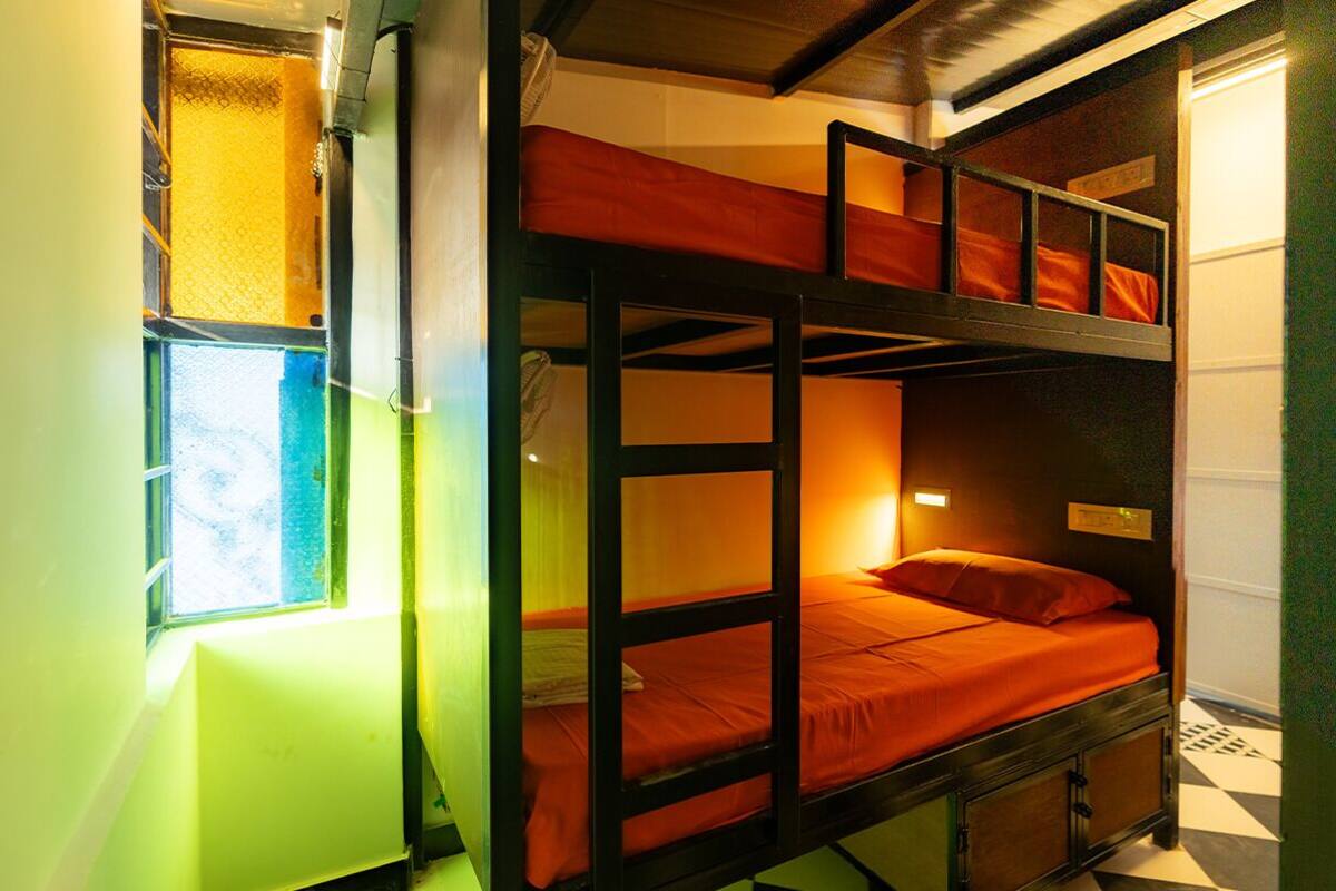 A bunk bed room with a window, a radiator, and a checkered floor.