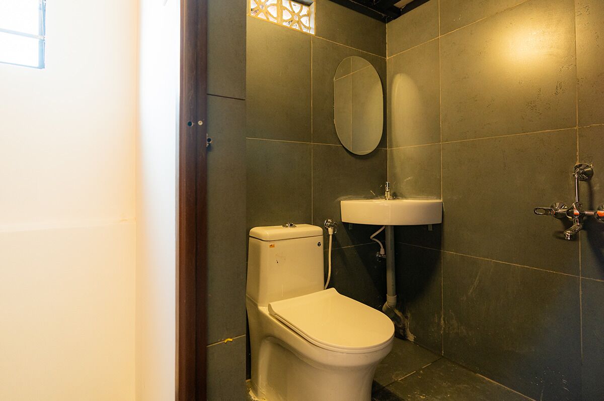 Un baño pequeño y moderno con inodoro, lavamanos y espejo.