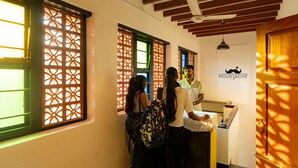 Un'area reception con banco check-in, pannelli decorativi alle finestre e un logo al muro.