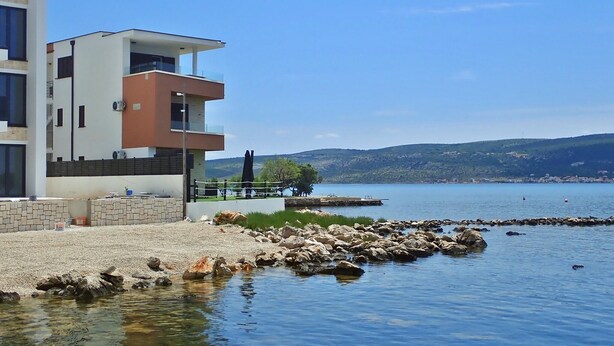 A modern building with a flat roof, large windows, and a stone facade. - Plava Laguna - Direkt am Strand und mit Meerblick (Seline)
