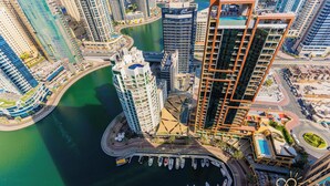 A high-rise hotel with a marina, featuring a curved building design and a pool area. - Stylish 1BR unit Address Marina (Dubai)
