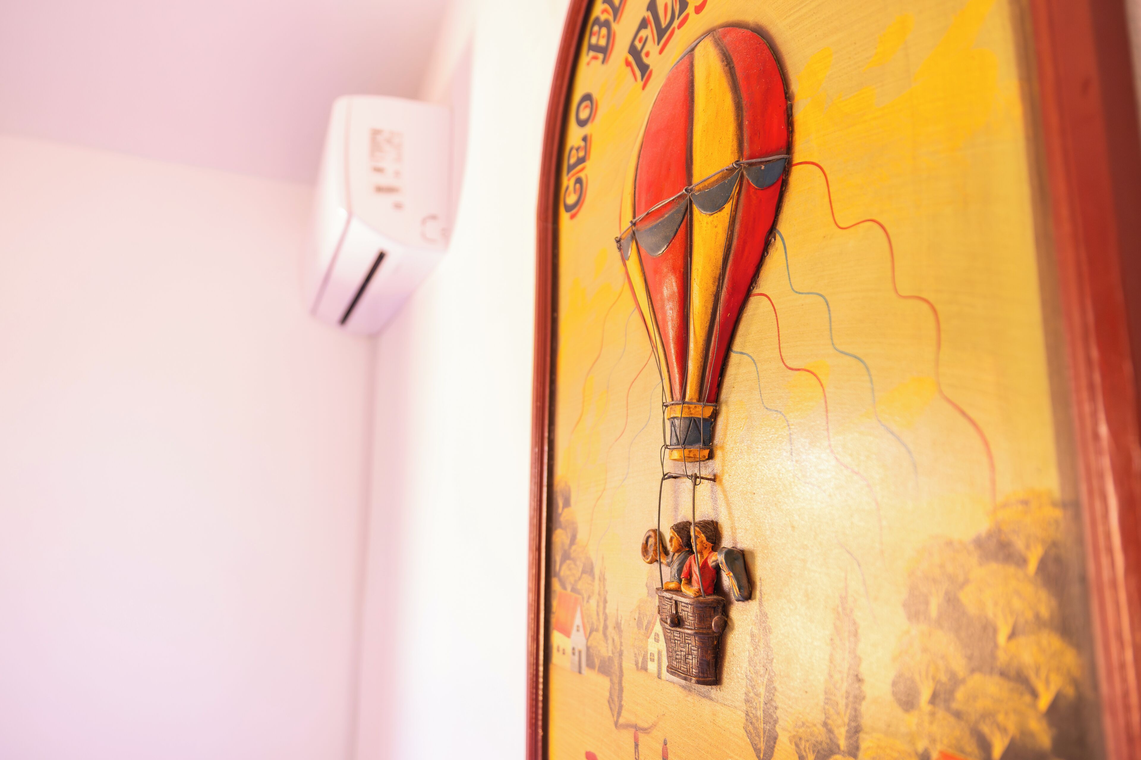 A wooden door with a hot air balloon design and a small figurine of a man in a pilot's outfit.